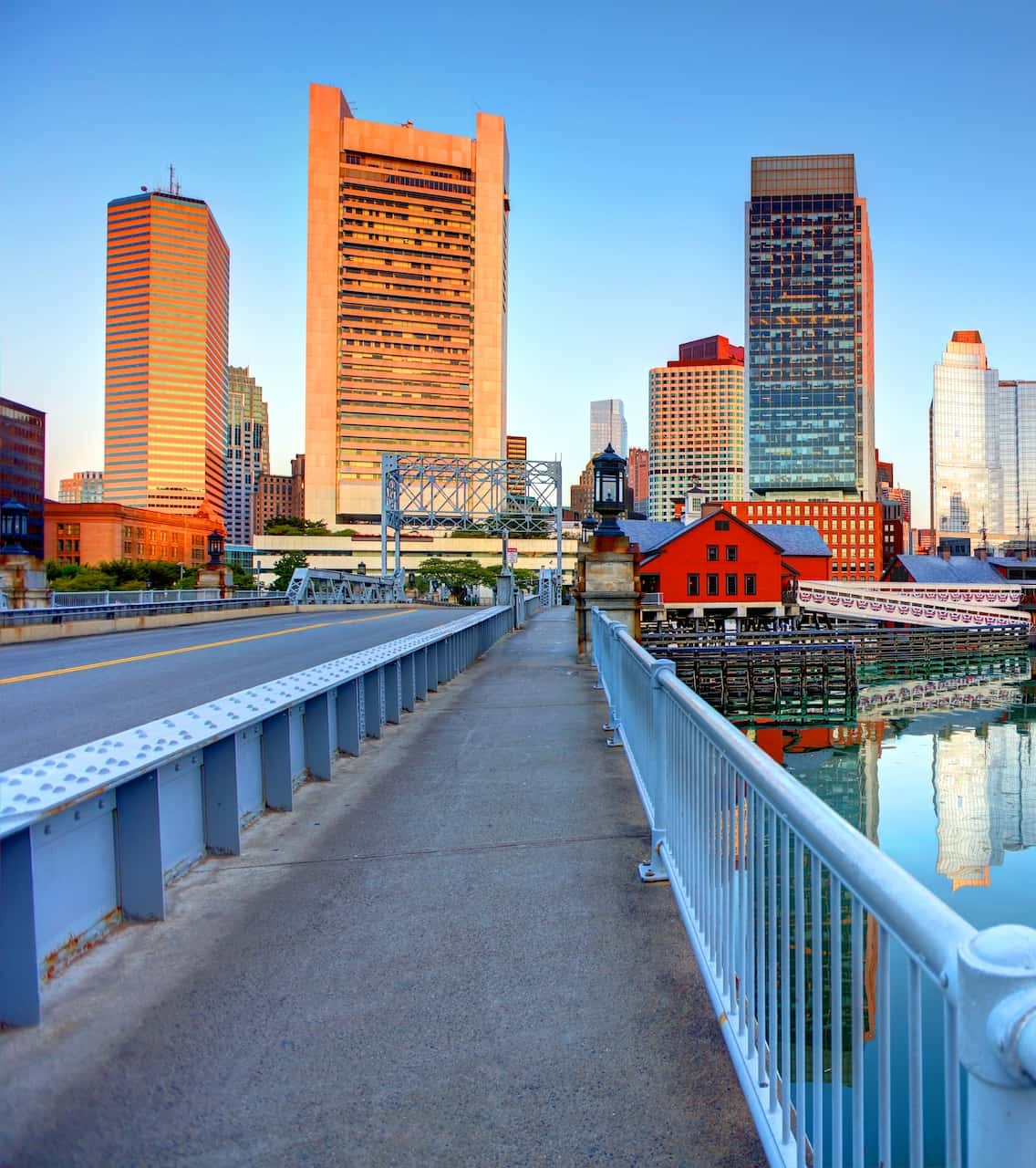 Rooted in growth. Powered by people. View of Boston's Financial District and Tea Party Museum at sunrise, taken from the Congress St. Bridge in Seaport