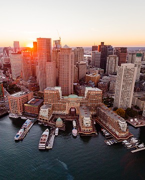 Contact Us. Let’s connect. Arial shot of Boston's waterfront at sunset.