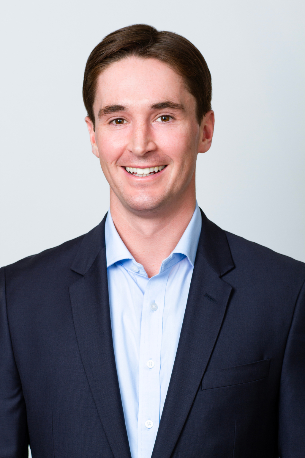 Alec Finigan CFA Senior Manager Marketing & Client Service professional headshot. He is wearing a blue button-down shirt and a navy blazer.