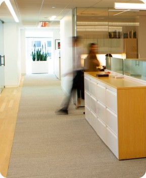 Employee-owned investment firm. Employees walking around office space.