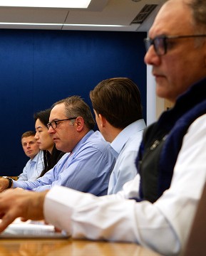 Contact Us. Let’s connect. Profile shot of employees in an investment committee meeting.