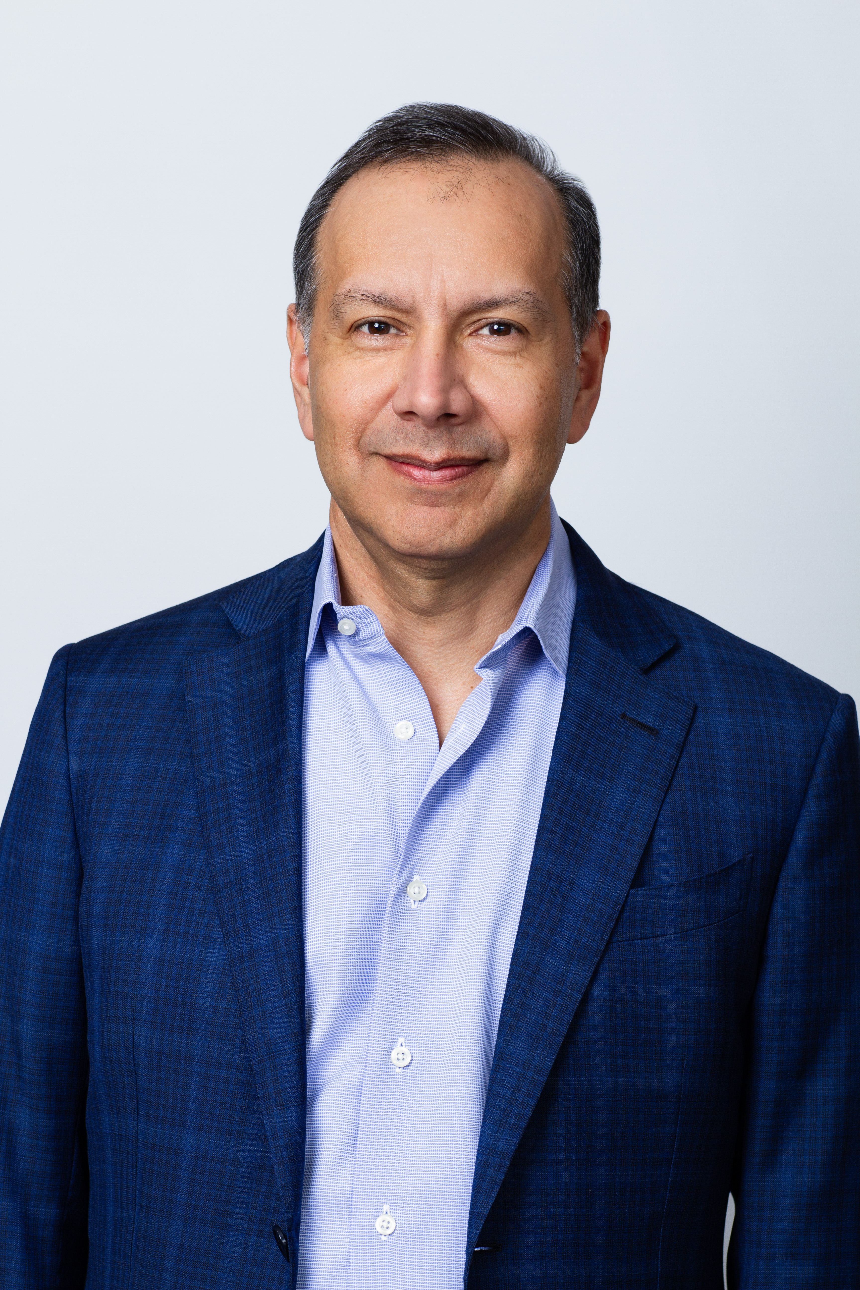 Rob Flores Director of Disruptive Technology Research professional headshot. He is wearing a blue button-down with a navy blazer.