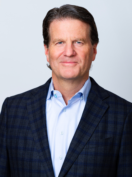 John Montgomery Portfolio Strategist & COO professional headshot. John wears a blue button-down and blue blazer.