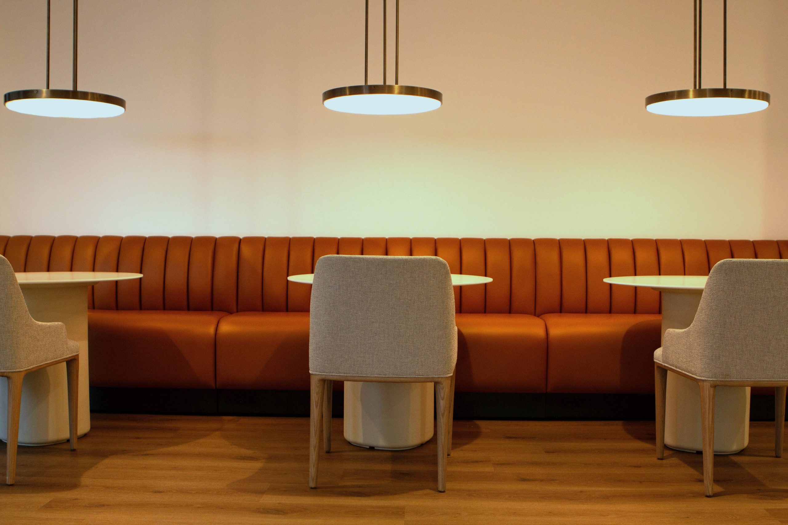 Rooted in growth. Powered by people. Image of employee lounge bistro tables under modern lighting fixtures.