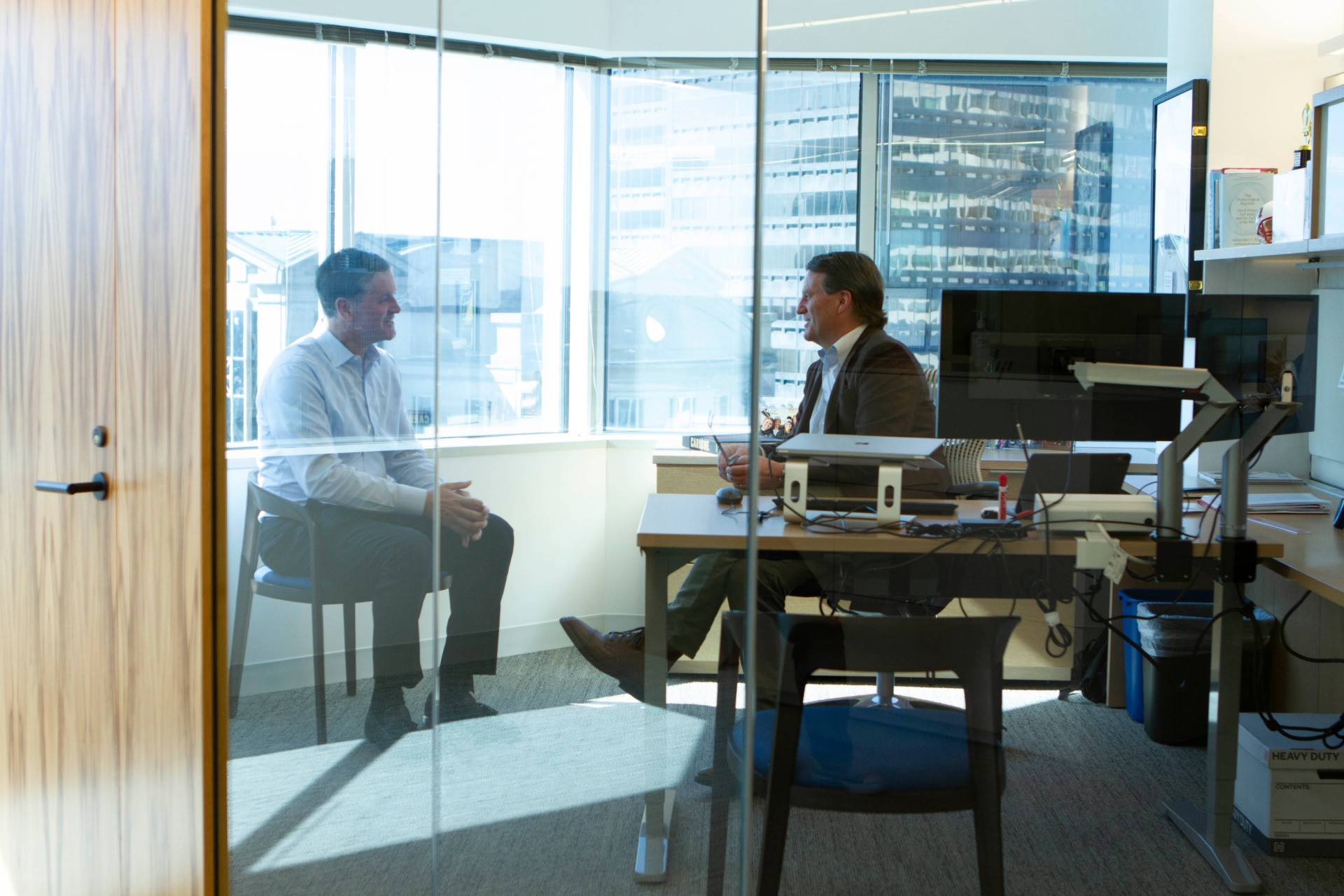 Employee-owned investment firm. Employees chatting in an office