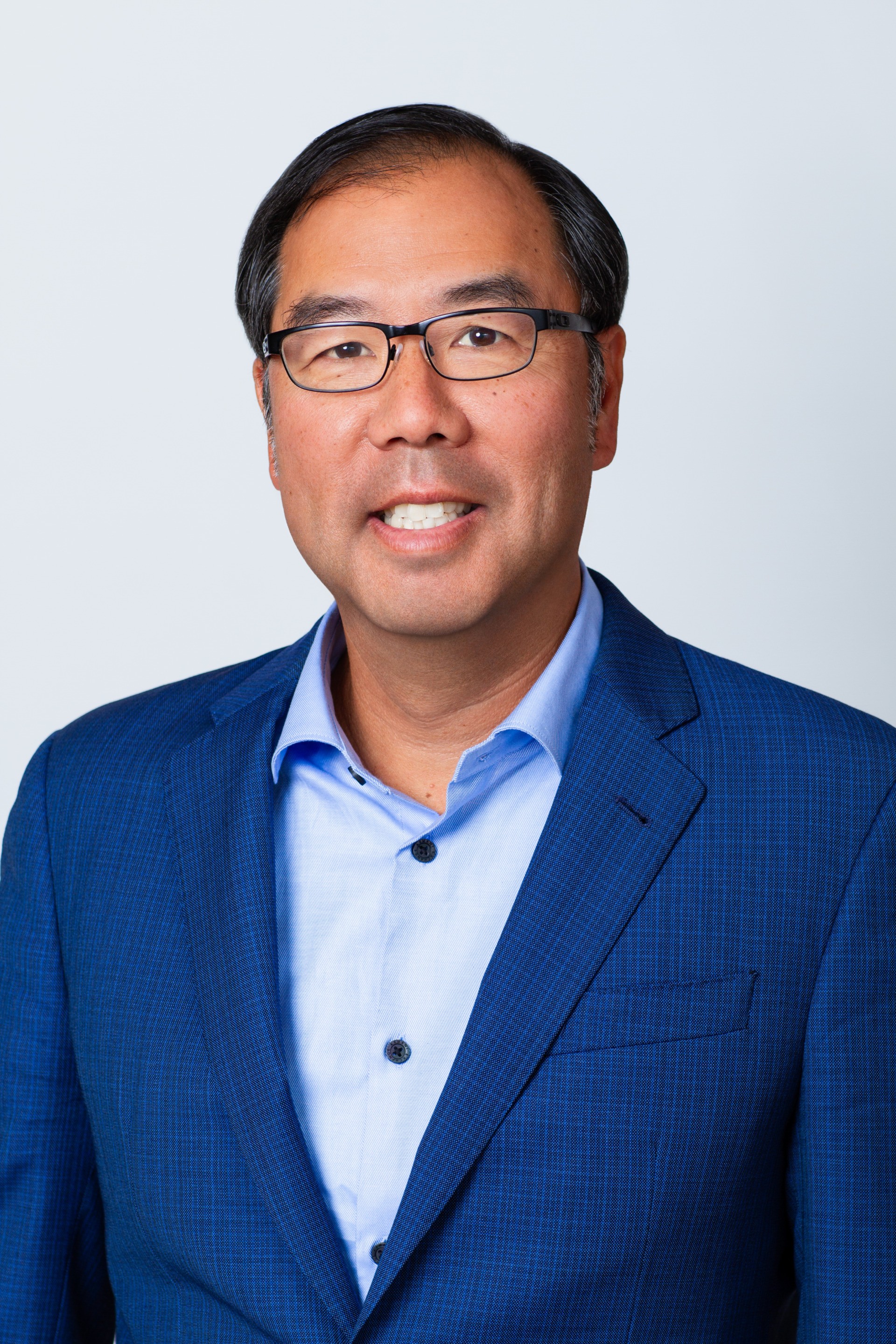 Rich Lee CFA Managing Partner CIO professional headshot. Rich wears a blue button-down shirt and dark blue blazer.