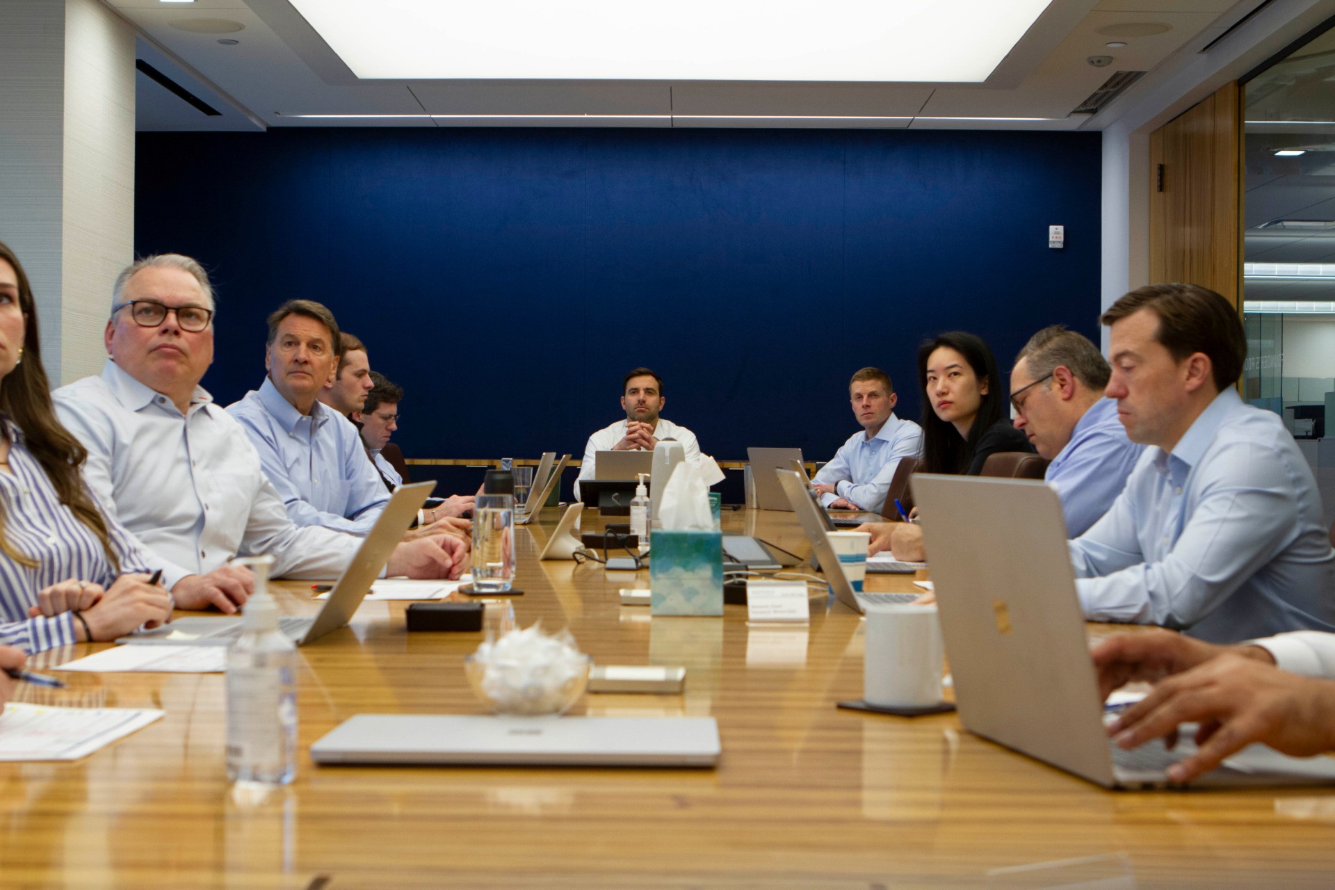 Employee-owned investment firm. Employees in board room.